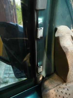 Takhle drží plastový trojúhelník se štelováním zrcátek.Pro sundání je třeba ho tlačit směrem k B sloupku a až to od těchto dvou spon odpadne,tak pak už ho drží jen jedna.Pak tedy zatáhnout směrem od dveří do interiéru…Chce to trochu síly…